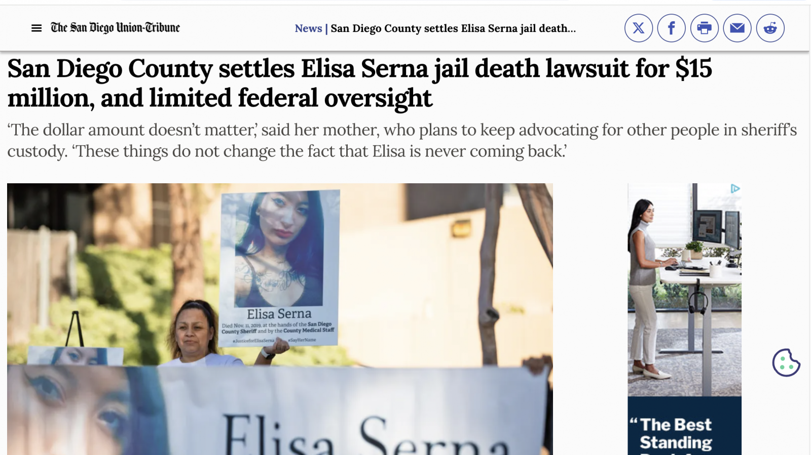 Paloma Serna, holds up a sign of her daughter, Elisa Serna, who died in jail in 2019, during a vigil and rally 